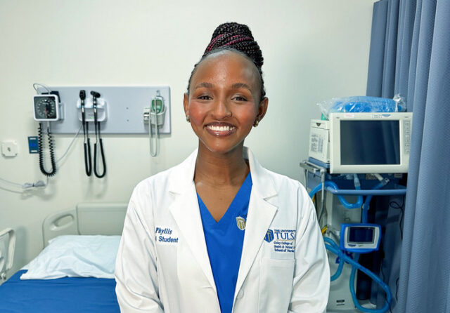 Phyllis Ekwempu, a nursing student at The University of Tulsa, smiles in a hospital room.