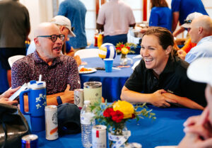 UTulsa volleyball fundraiser: couple laughs at a table with drinks and decorations.