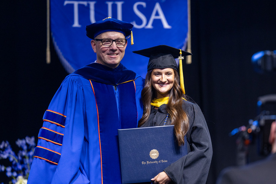 Tulsa University commencement 2026: graduate receives diploma from professor.