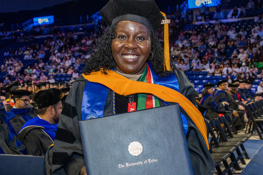 University of Tulsa graduate in cap and gown holds diploma at 2026 commencement.