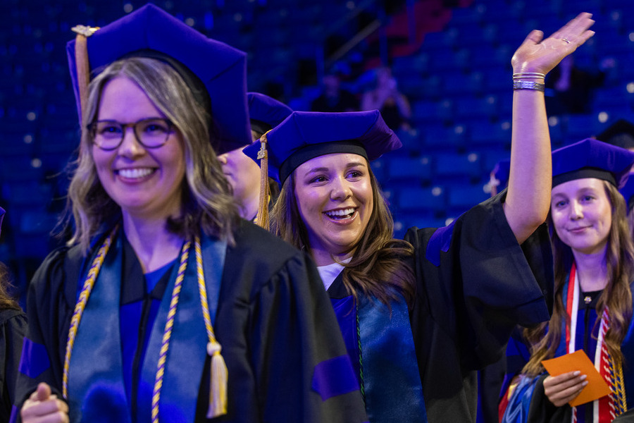 Law graduates in caps and gowns wave at commencement 2026.