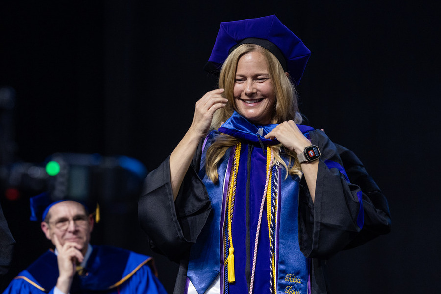 Graduate in blue cap and gown at 2026 commencement.