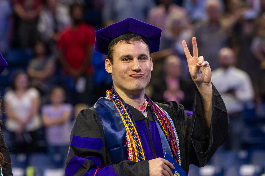 Graduate making peace sign at commencement 2026 law ceremony