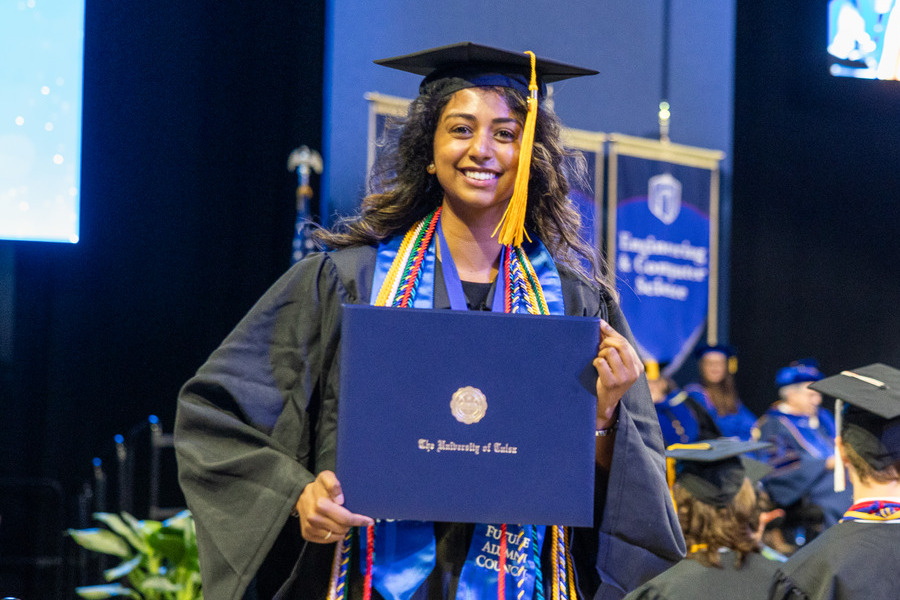 Happy graduate holding diploma at commencement 2026