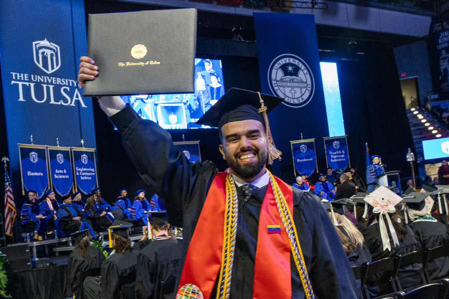 Happy graduate holding diploma at 2026 commencement ceremony
