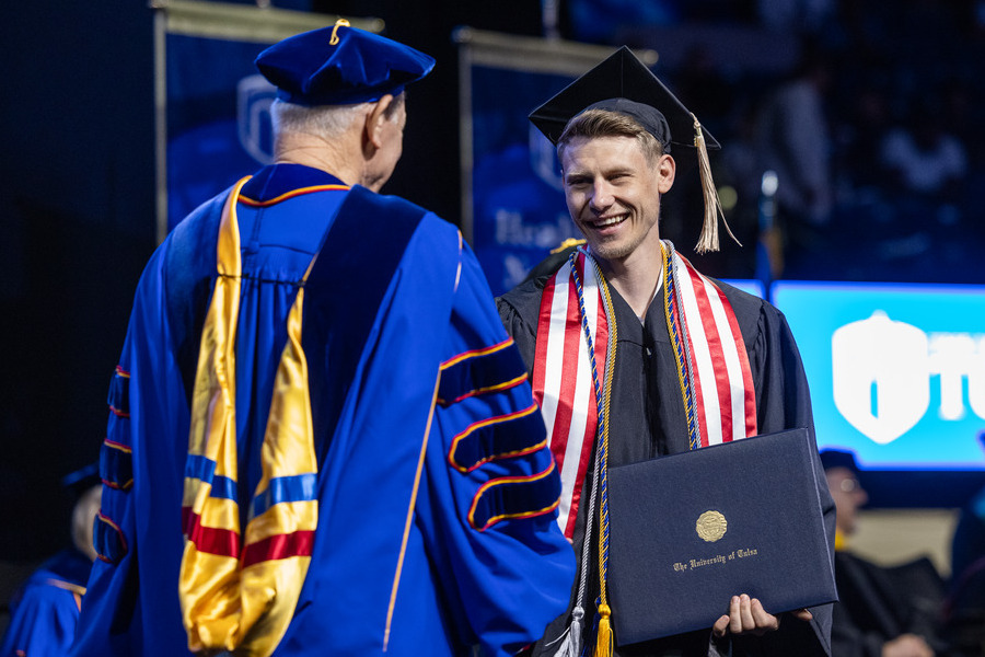 Graduate receives diploma at Commencement 2026.