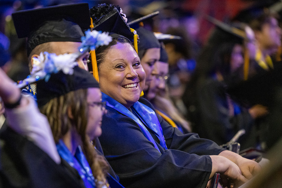 Smiling graduate in cap and gown at commencement 2026