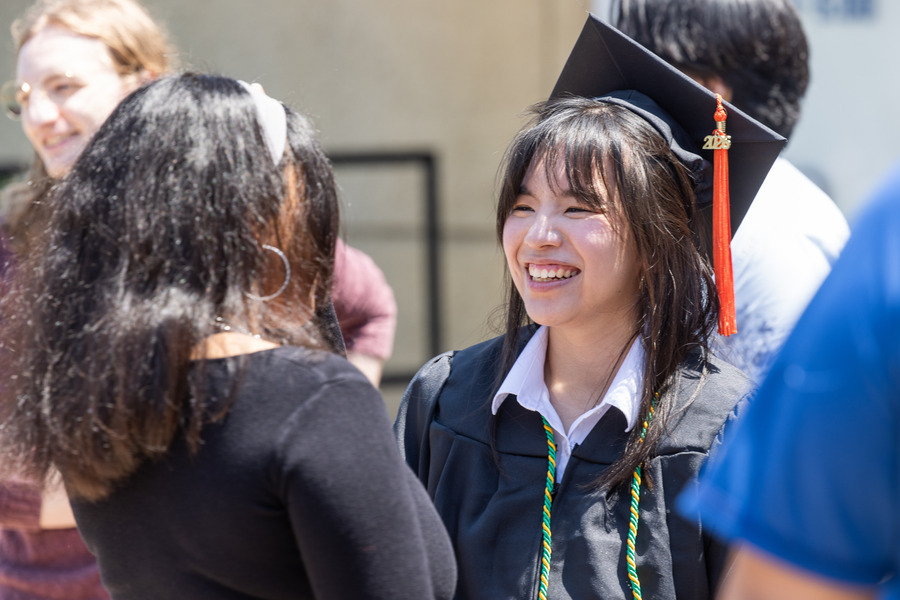 Happy graduate in cap and gown at commencement 2026.