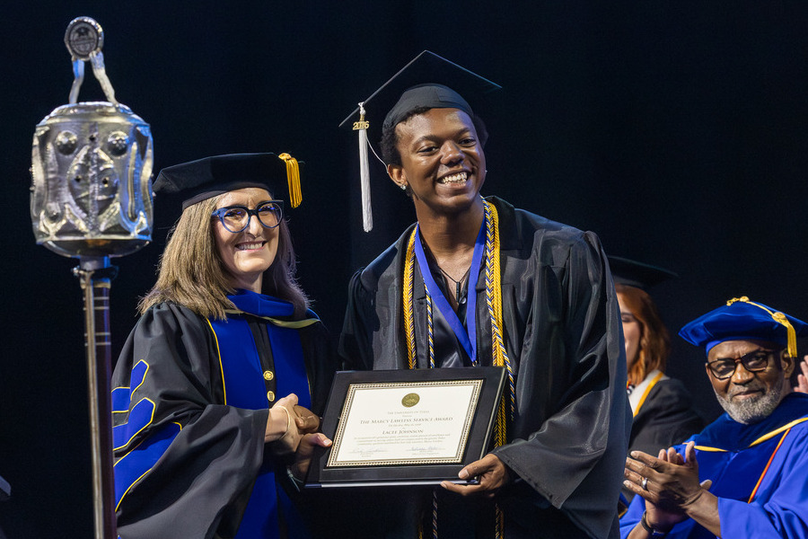 Graduate receives award at 2026 commencement ceremony.