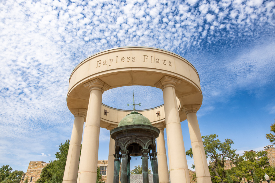 The Kendall Bell at Bayless Plaza with blue sky and clouds