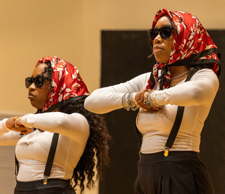 Two women in matching outfits performing a dance