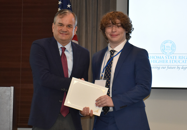 Man presents certificate to student at 2026 Mid-America AIChE conference