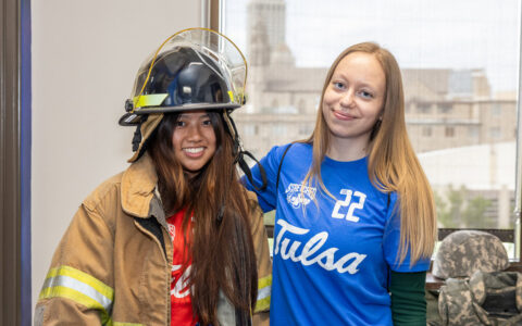 Two young women, one in firefighter gear