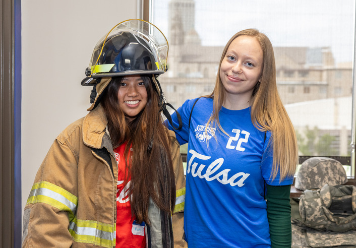 Two young women, one in firefighter gear