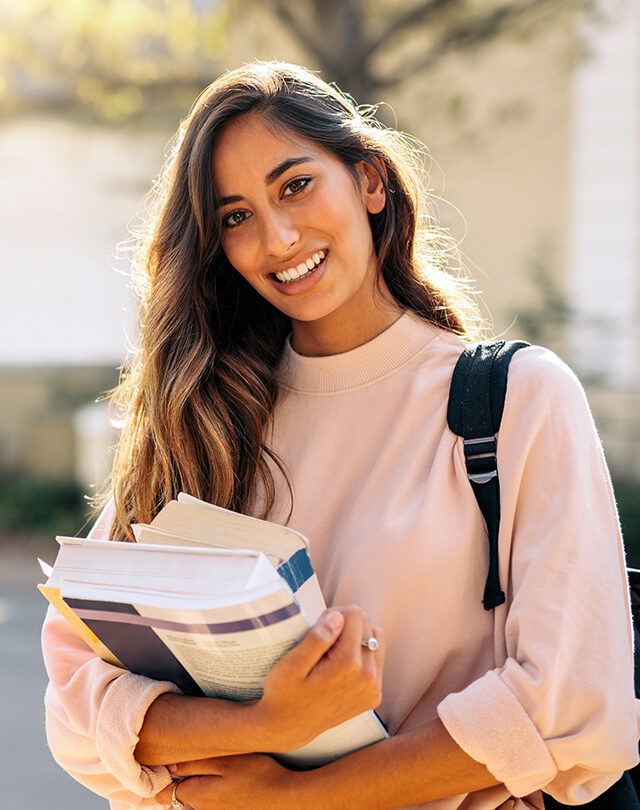 Smiling student holding books
