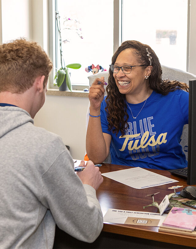 UTulsa academic adviser meets with a student in an office