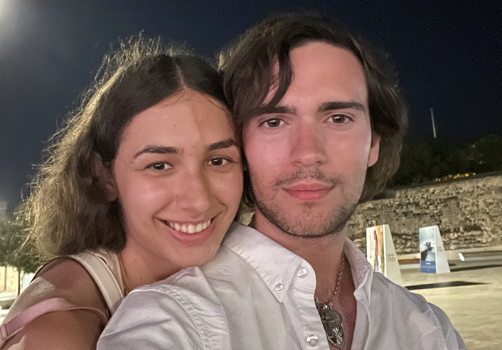 Selfie of a smiling woman and man in a courtyard at night