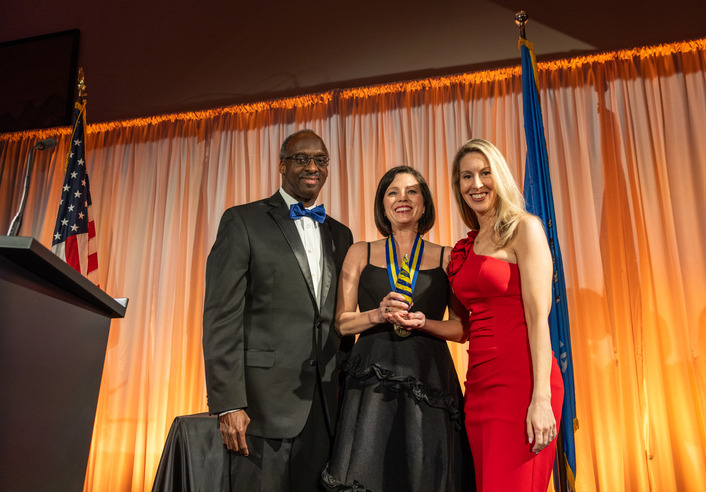 Alumna receives award with presenters