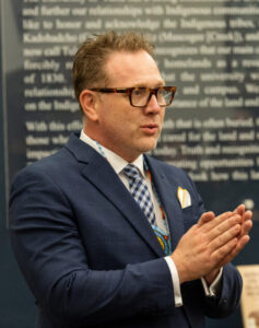 Dean in suit speaking