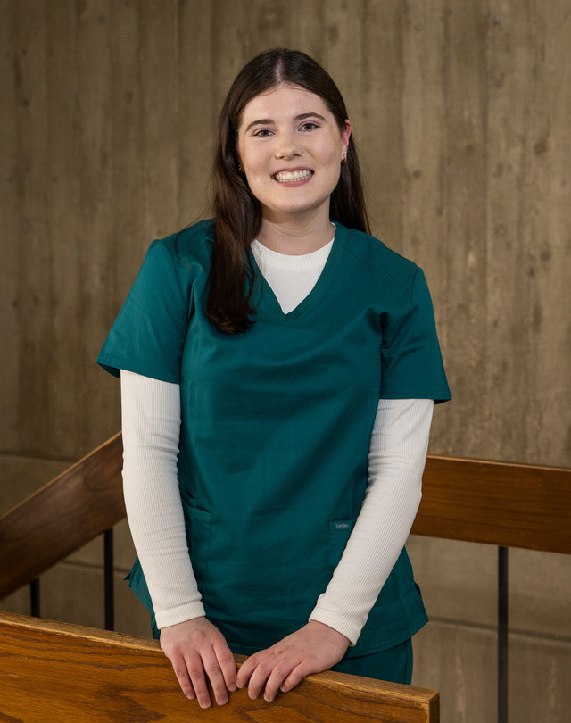 Speech-language pathology student in teal scrubs