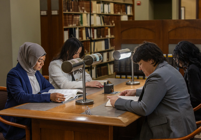 Students studying at library tables