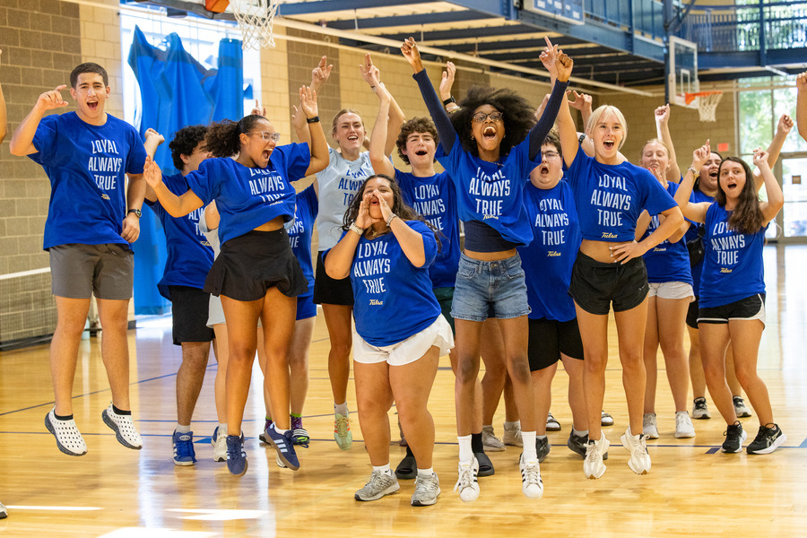 Students in blue shirts celebrating at orientation