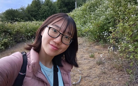 Young woman in glasses and pink jacket