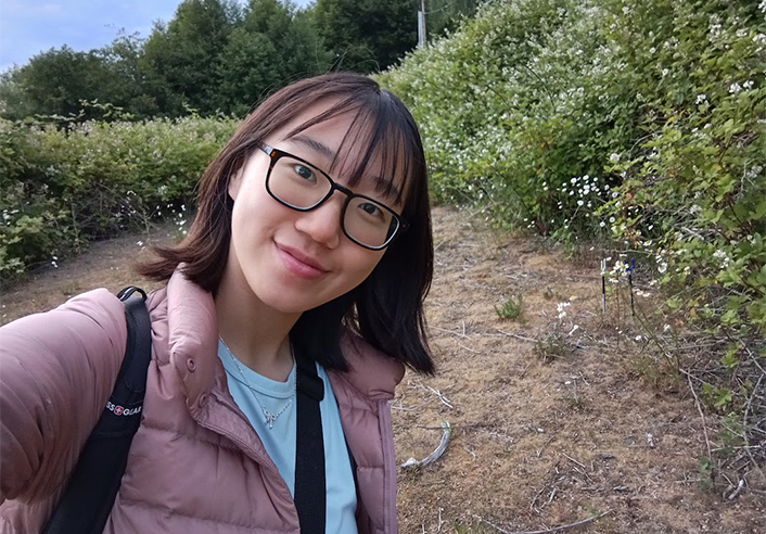Young woman in glasses and pink jacket