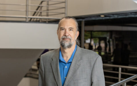 Dr. Redner in a grey suit and blue shirt