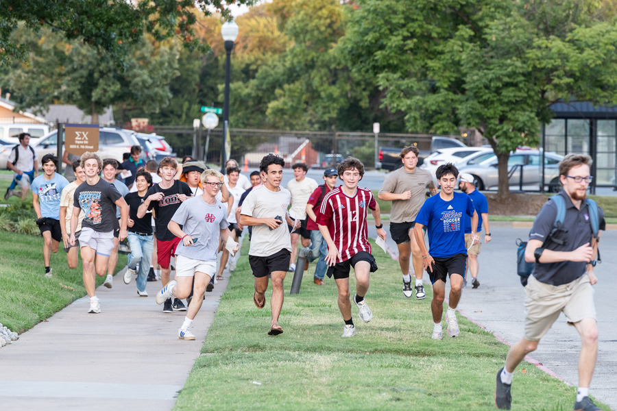 Young men running to their new fraternity during Bid Day 2026