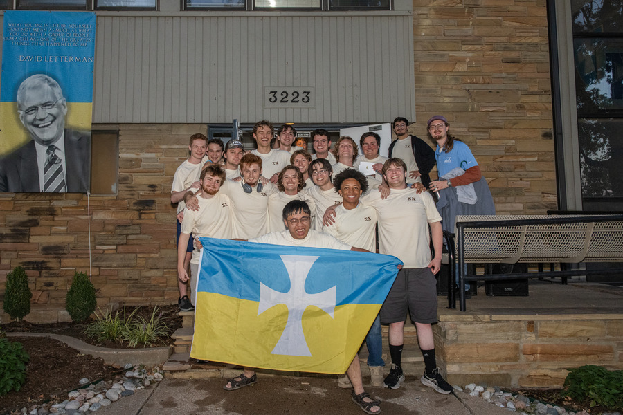 Men pose outside Sigma Chi fraternity house