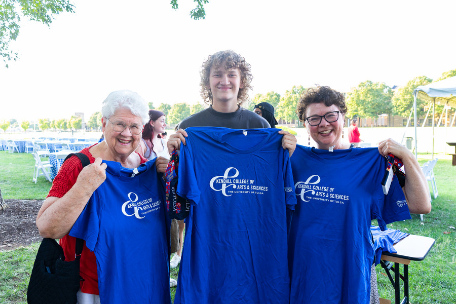 Family and students pose with Kendall College tee shirts