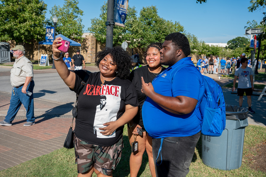 A family takes a selfie at the tailgate