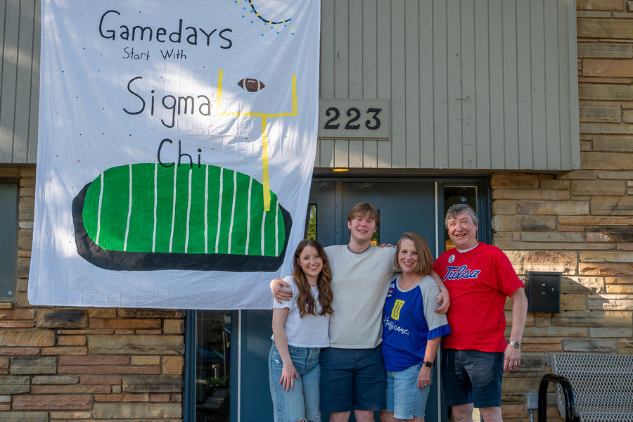 Family poses with Sigma Chi banner