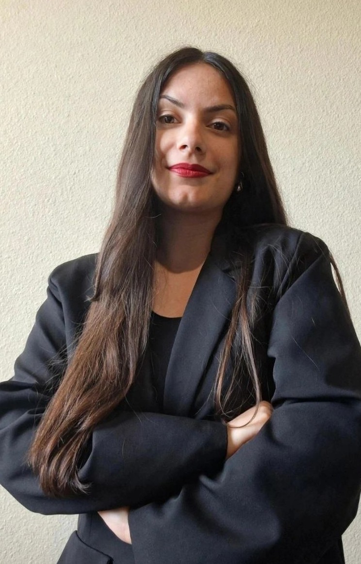Woman in black blazer, arms crossed
