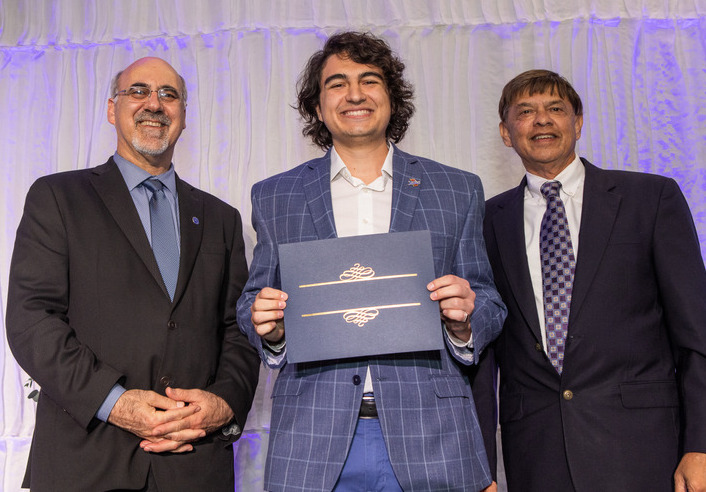 Award recipient with two men