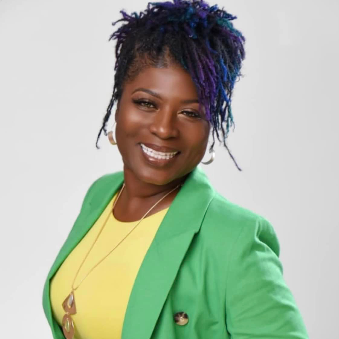 Woman with dreadlocks in green blazer