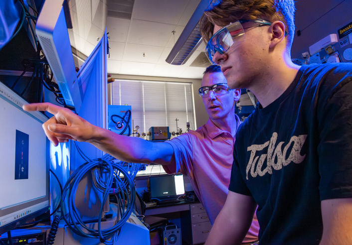 Researchers in lab pointing at screen