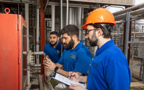 UTulsa students inspect industrial equipment.