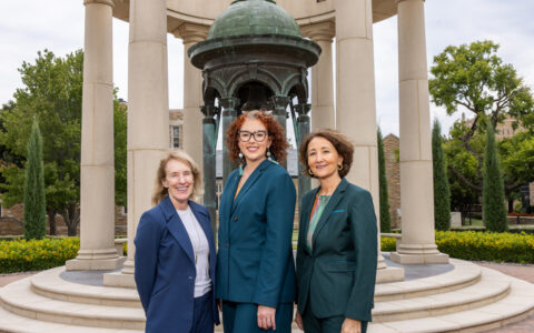 Three women in suits outside