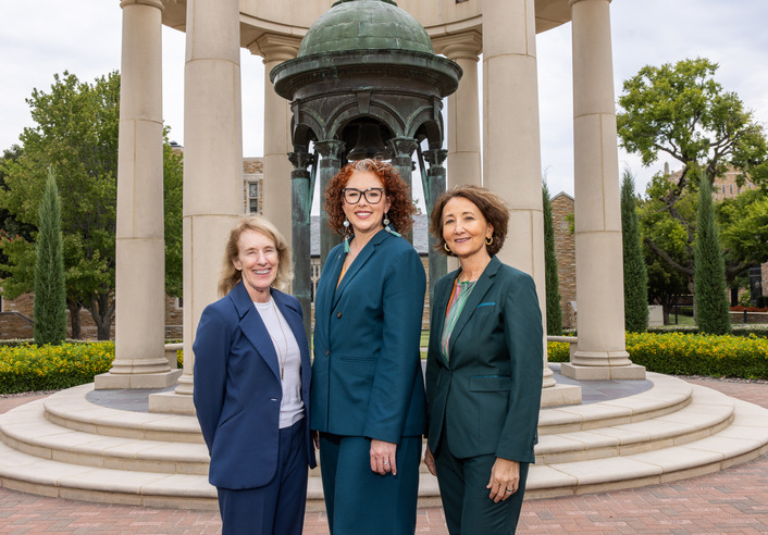 Three women in suits outside