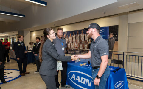 Two professionals shake hands at AAON booth