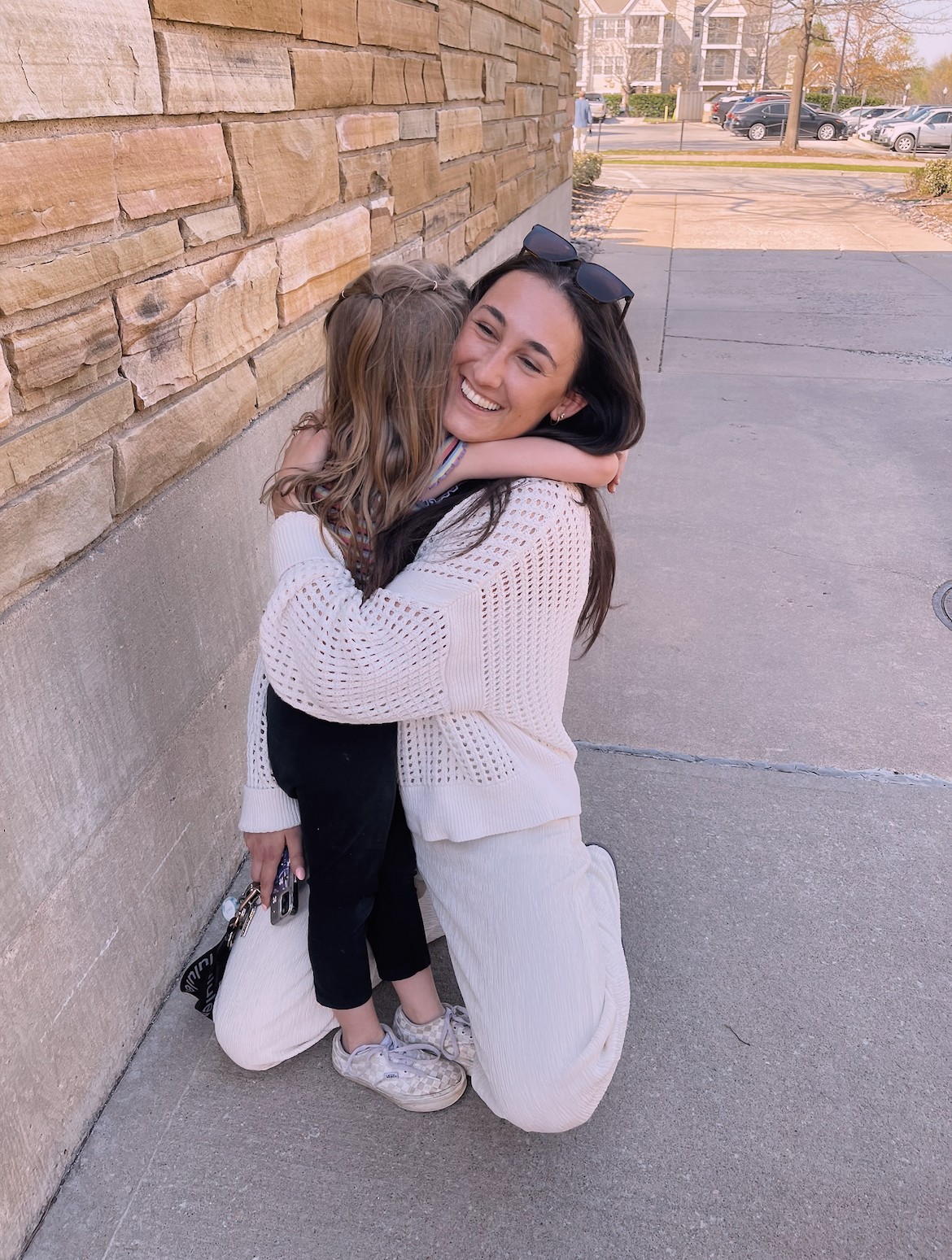 Alumna hugs child
