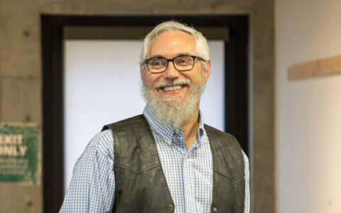 Man with beard and glasses smiles